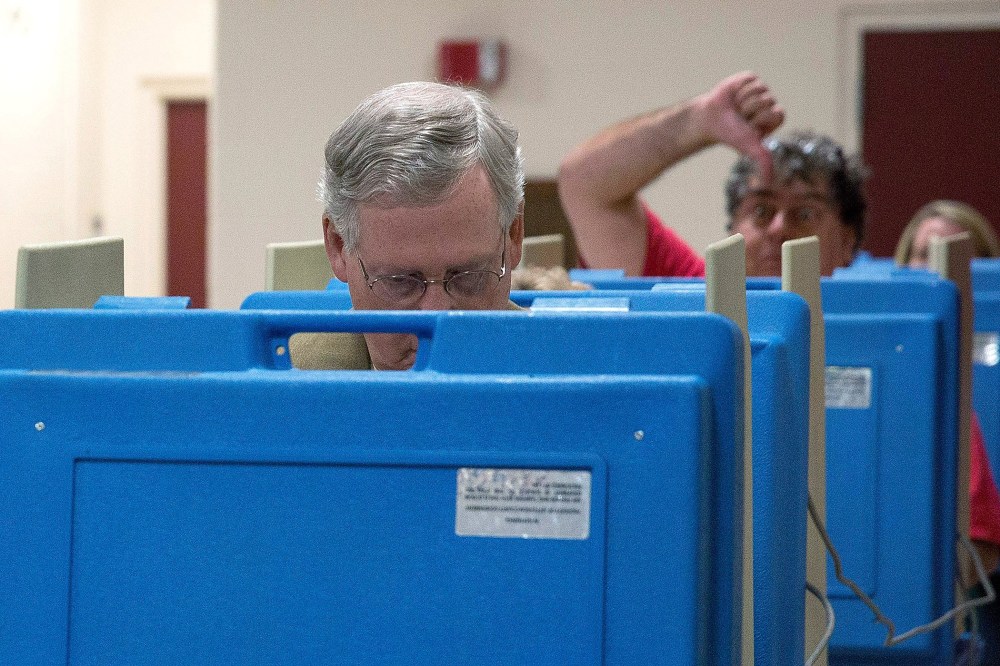 A voter gestures as Senate Minority Leader U.S. Sen. Mitch McConnell (R-KY) votes in the midterm elections at Bellarmine University on Nov. 4, 2014 in Louisville, Ky.