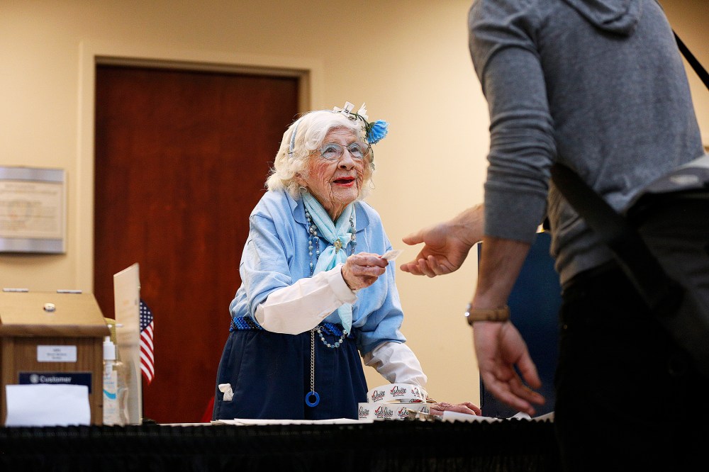 Elections judge Constance Rolon, 96, of Denver, Colorado hands out "I Voted!" stickers as voters cast their ballots at the Denver Elections Division Building on Nov. 4, 2014.