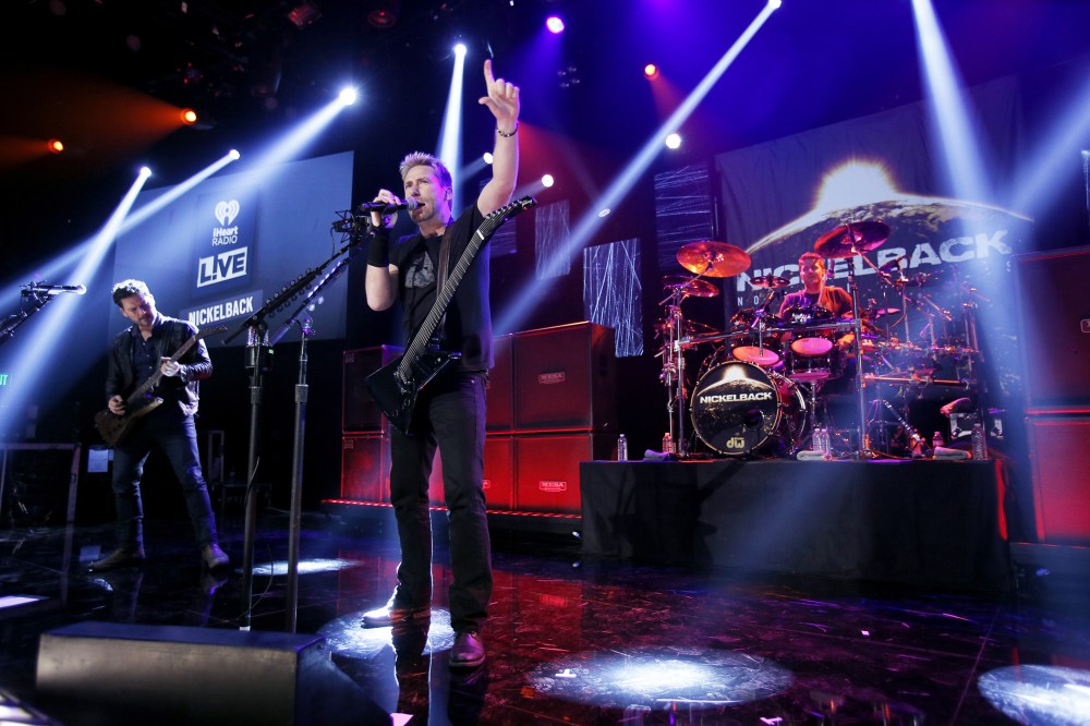 (L-R) Ryan Peak, Chad Kroeger and Daniel Adair from the band Nickelback perform at iHeartRadio Theater on Nov. 18, 2014 in Burbank, Calif. (Photo by Mike Windle/Getty for iHeartMedia)