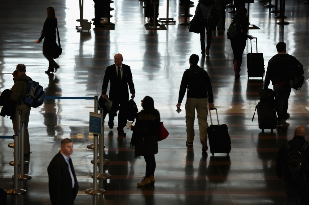 Travelers arrive at an airport. (Photo by Alex Wong/Getty)