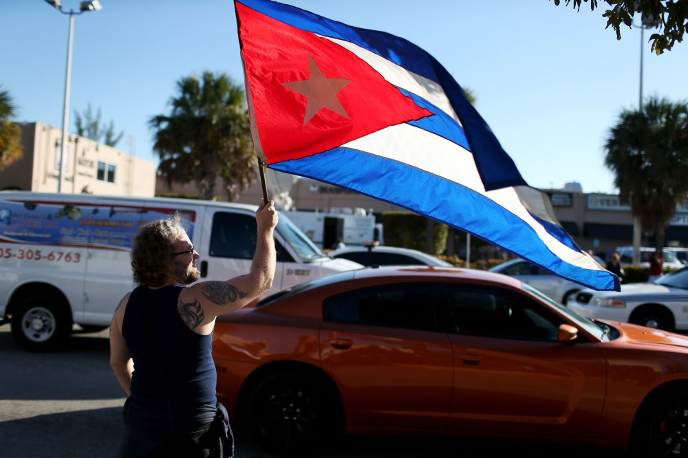 Abdel Rodriguez holds a Cuban flag as he stands outside the Little Havana restaurant Versailles on Dec. 17, 2014 in Miami, Fla. (Joe Raedle/Getty)