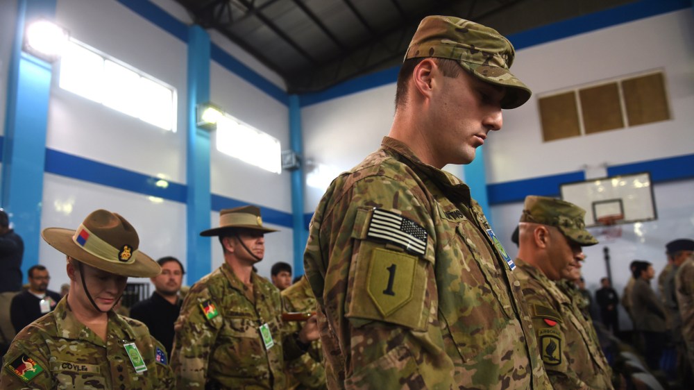 NATO-led International Security Assistance Force (ISAF) bow their heads during a ceremony marking the end of ISAF's combat mission in Afghanistan at ISAF headquarters in Kabul on Dec. 28, 2014. (Photo by Shah Marai/AFP/Getty)