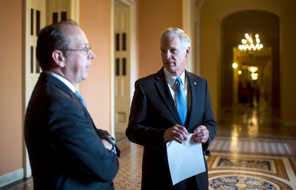 From left, Paul Clement, former United States Solicitor General, and Sen. Ron Johnson, R-Wisc., talk in the hallway before the start of their news conference on Jan. 6, 2014, to announce a lawsuit against the Office of Personnel Management challenging an