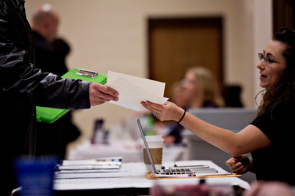 A job seeker talks to a potential employer during a Princeton Area Chamber of Commerce job fair in Princeton, Ill. on Jan. 5, 2015.