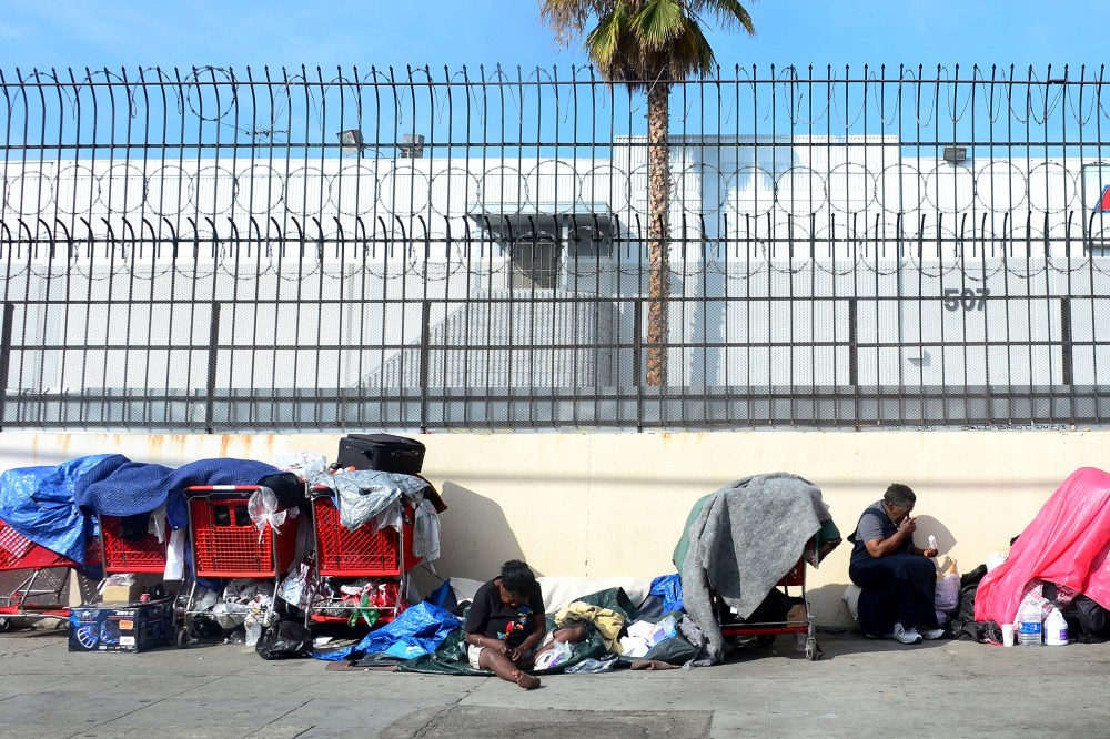 Homeless women sit amid their belongings on a street in downtown Los Angeles, California, on January 8, 2014.
