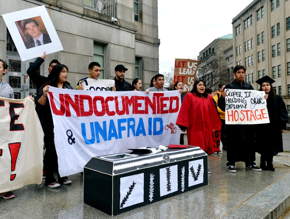Immigration activists chant behind a cardboard coffin on the front steps of the North Carolina Attorney General's office in Raleigh, N.C., Jan. 11, 2014. (Photo by Chuck Liddy/Raleigh News & Observer/MCT)