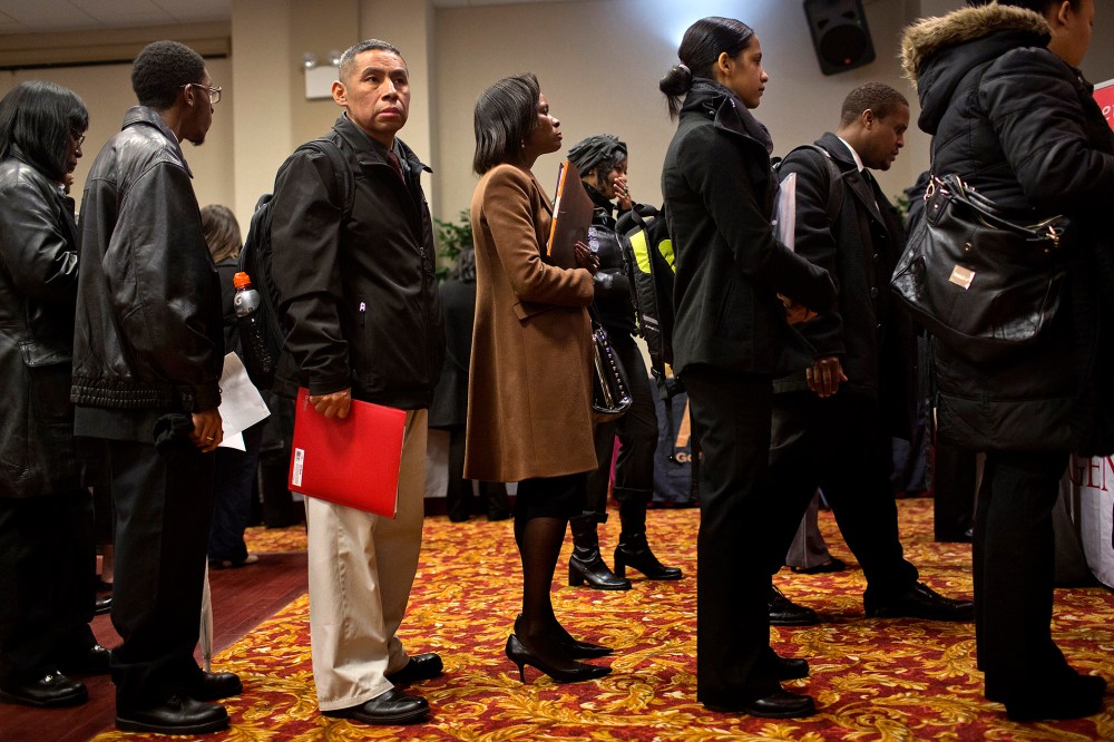 Job seekers wait to talk to recruiters and fill out applications at a job fair in New York, U.S., on Jan. 16, 2014.