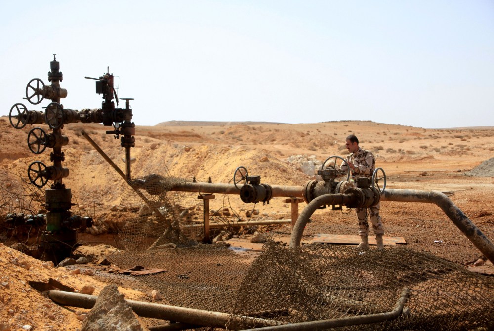 Syrian government soldier stands next to a well at Jazel oil field, after retaking the area from Islamic State fighters on March 9, 2015. Recent US-led coalition air strikes have frequently targeted oil facilities run by IS. (Photo by STR/AFP/Getty)
