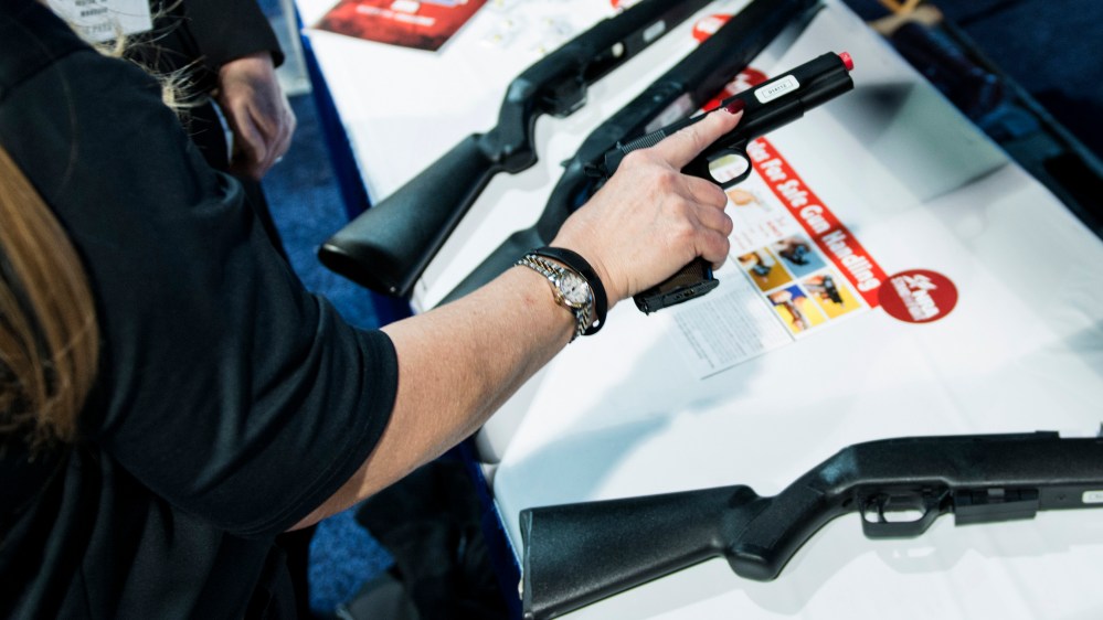 An instructor shows the proper way to hold a hand gun at an National Rifle Association virtual shooting booth during the American Conservative Union Conference March 6, 2014 in National Harbor, Maryland.