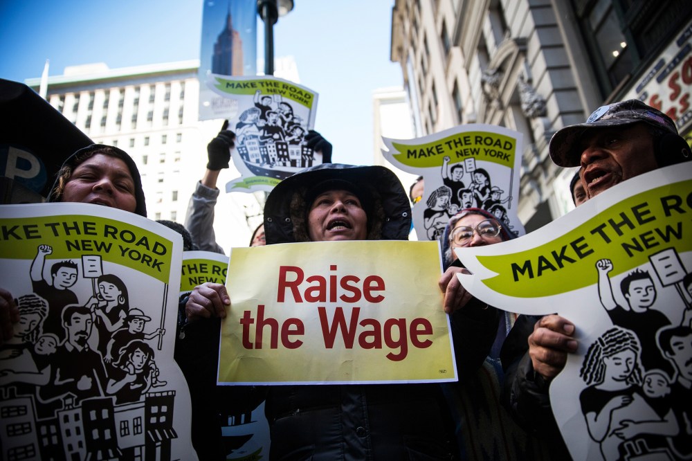 Women hold banners during a protest for higher wages for fast food workers on March 18, 2014 in New York, N.Y. (Photo by Andrew Burton/Getty)