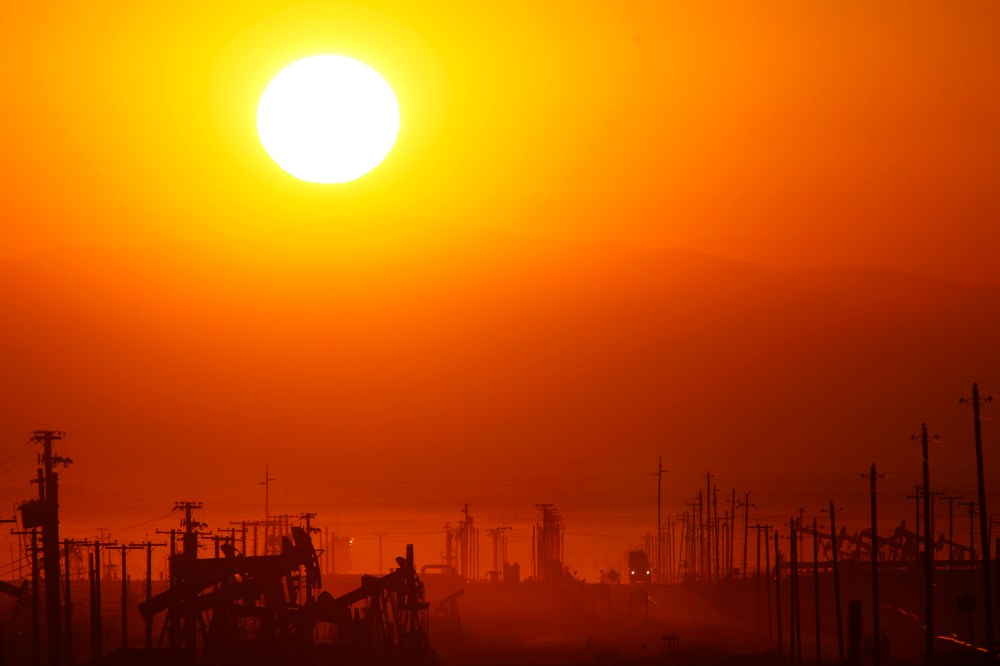 The sun rises over an oil field over the Monterey Shale formation where gas and oil extraction using hydraulic fracturing, or fracking, is on the verge of a boom on March 24, 2014 near Lost Hills, Calif. (Photo by David McNew/Getty)