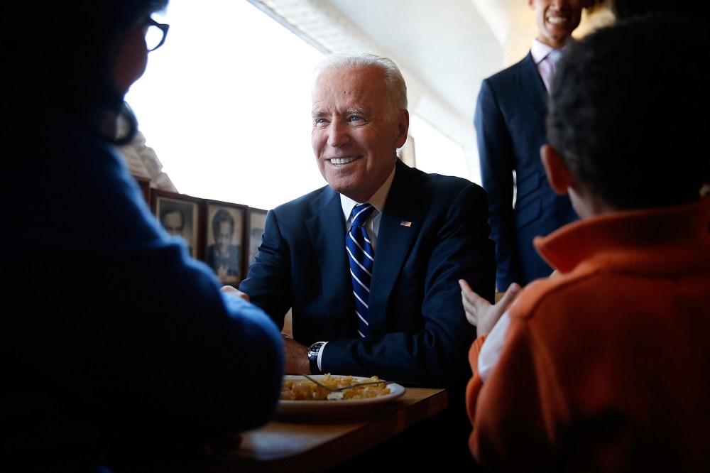 U.S. Vice President Joe Biden sits with customers while visiting a restaurant on March 26, 2014 in Washington, DC.
