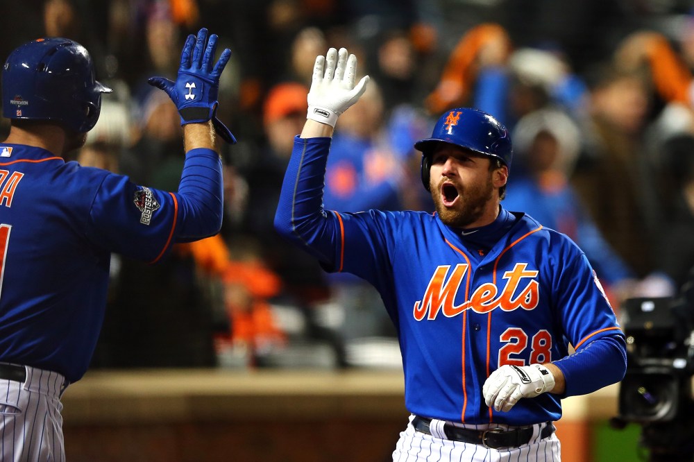 Daniel Murphy #28 of the New York Mets celebrates with his teammates after hitting a two run home run in the first inning against Jake Arrieta #49 of the Chicago Cubs during game two. (Photo by Elsa/Getty)