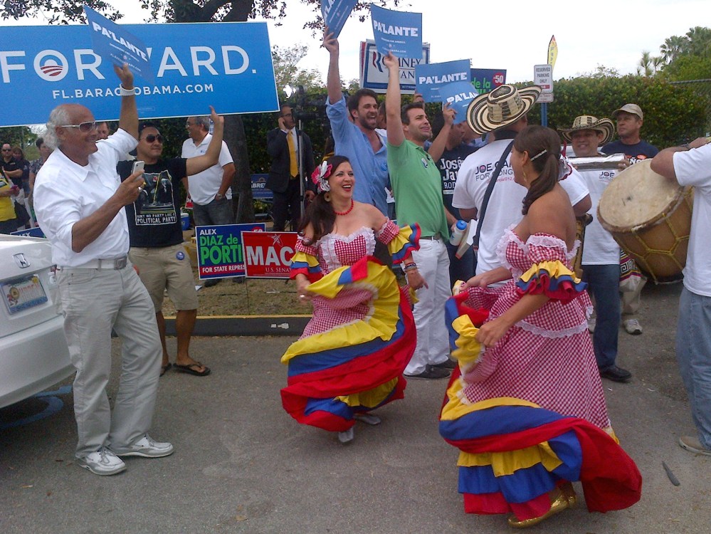Dancers perform as more than 250 people line up outside the Miami-Dade elections headquarters in Doral, Florida, on November 5, 2012 to cast absentee ballots in person, a day after a temporary shutdown at the site led to widespread confusion. (Photo...