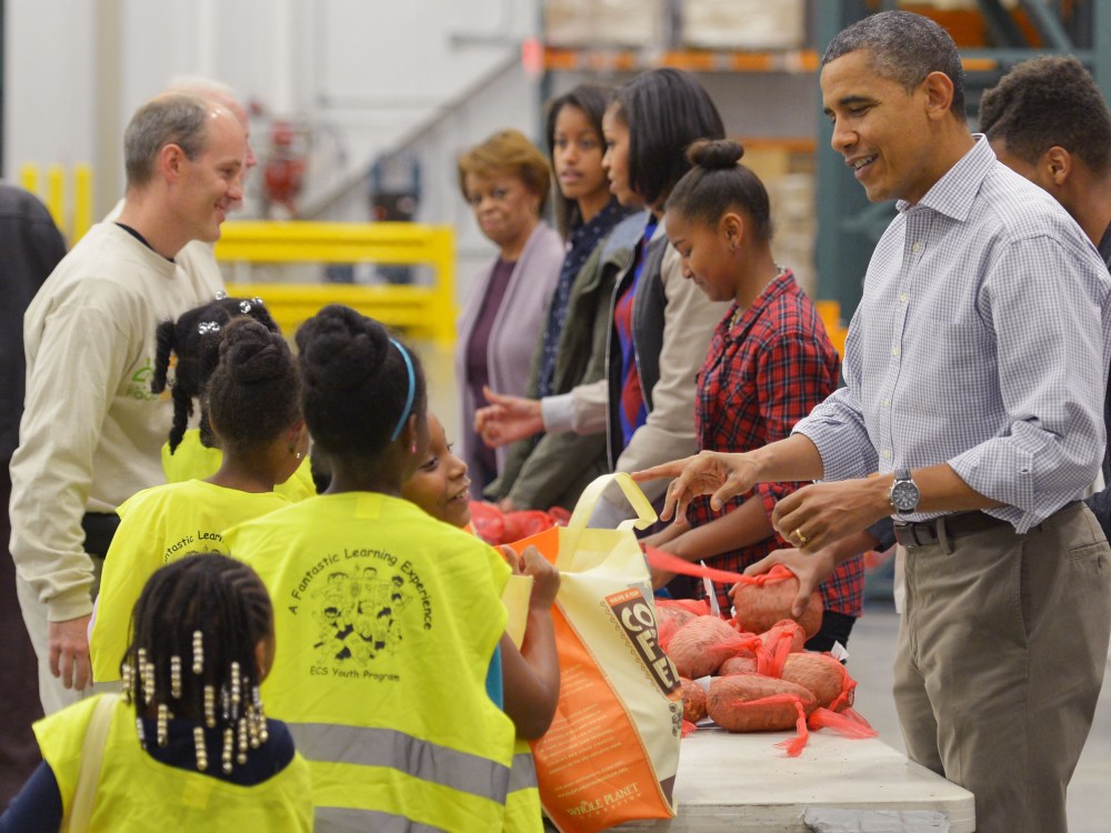 (R to L) US President Barack Obama, daughter Sasha, First Lady Michelle Obama, daughter Malia and mother-in-law Marian Robinson, distribute food at the Capitol Area Food Bank on November 21, 2012, a day ahead of Thanksgiving, in Washington, DC. (Photo...