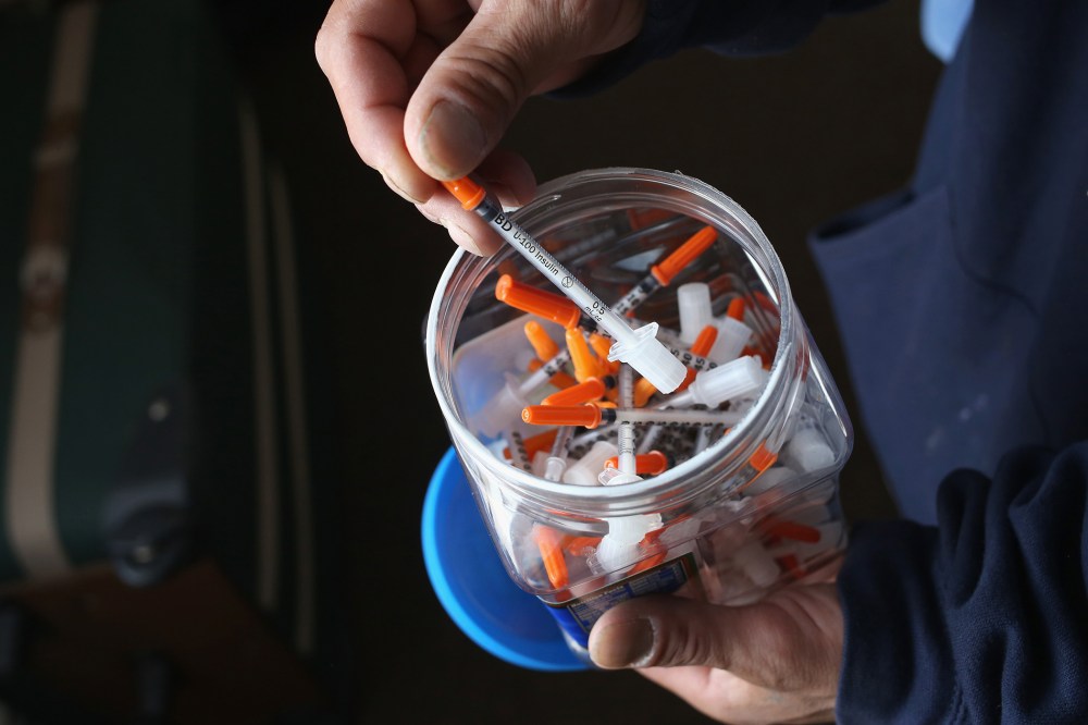A drug user takes a needle before injecting himself with heroin on March 23, 2016 in New London, CT. (Photo by John Moore/Getty)