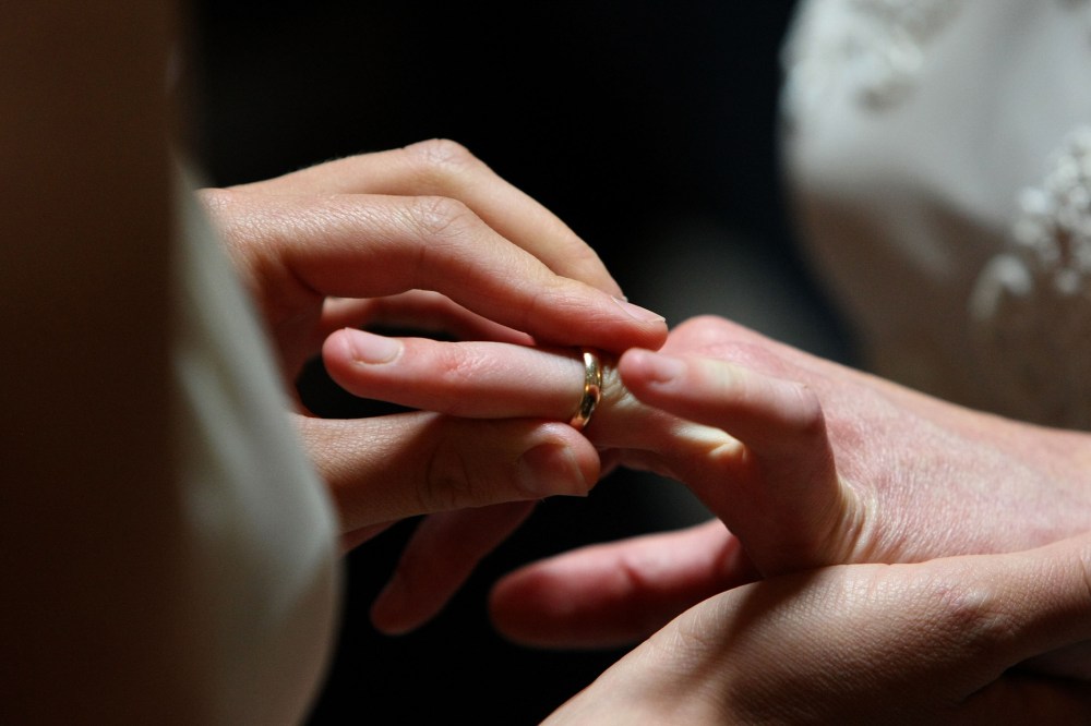A same-sex couple exchanges rings at a wedding.