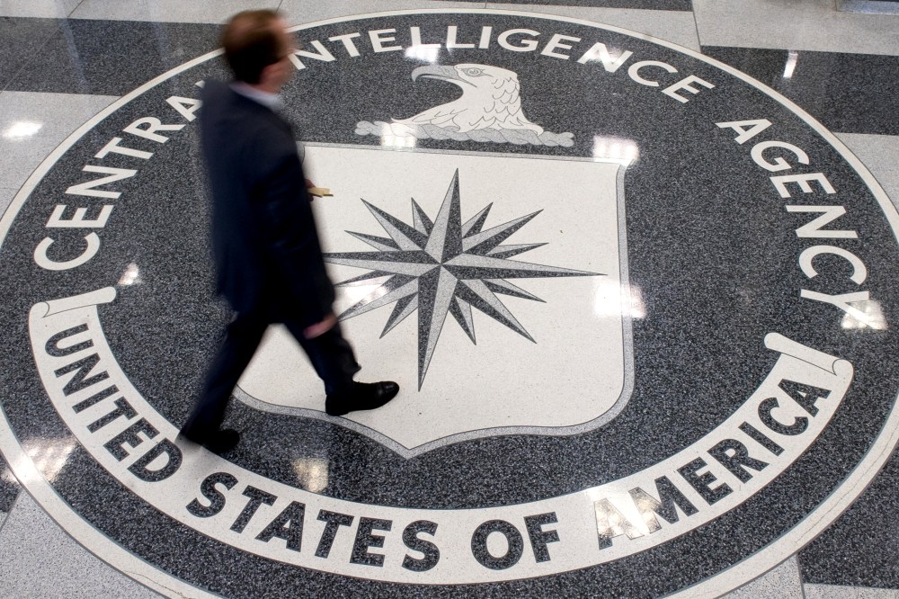 A man crosses the Central Intelligence Agency (CIA) logo in the lobby of CIA Headquarters in Langley, Virginia.