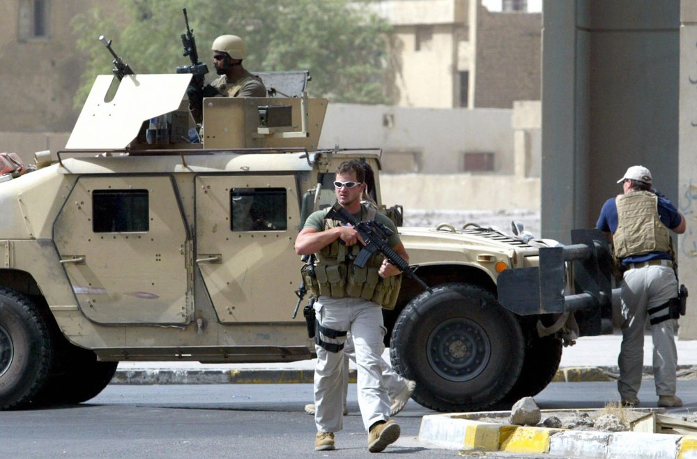 A picture taken on July 5, 2005 shows contractors of the U.S. private security firm Blackwater securing the site of a roadside bomb attack near the Iranian embassy in central Baghdad.