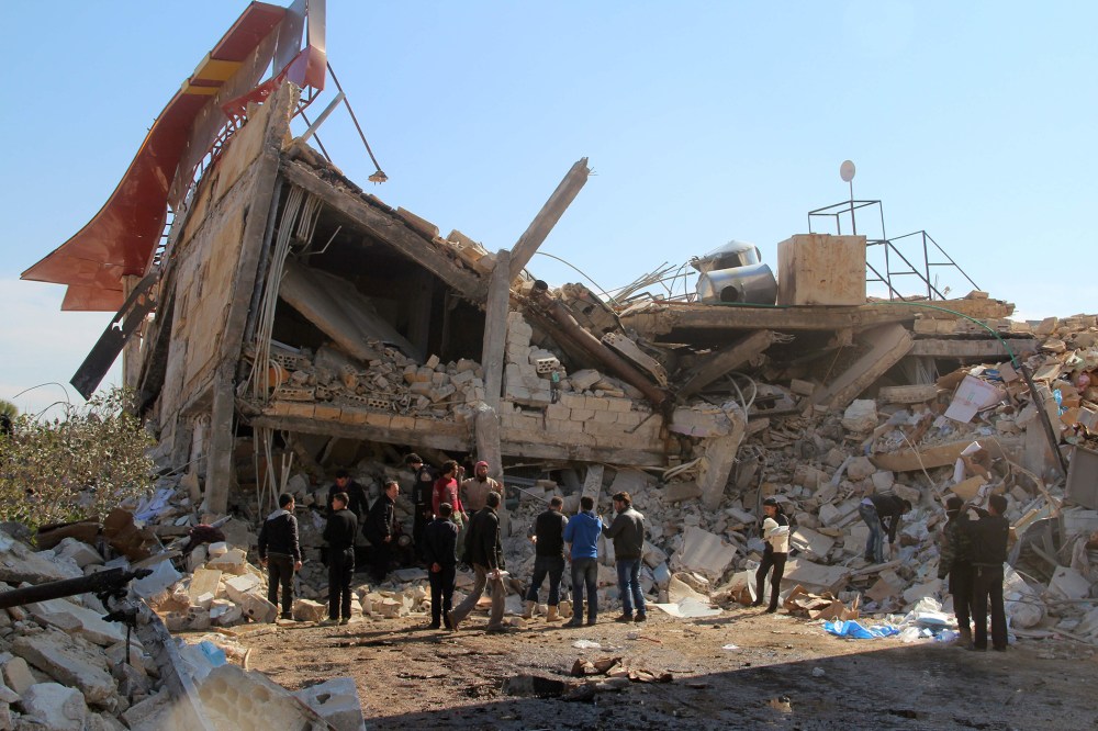 People gather around the rubble of a hospital supported by Doctors Without Borders (MSF) near Maaret al-Numan, in Syria's northern province of Idlib, on Feb. 15, 2016. (Photo by Ghaith Omran/AFP/Getty)
