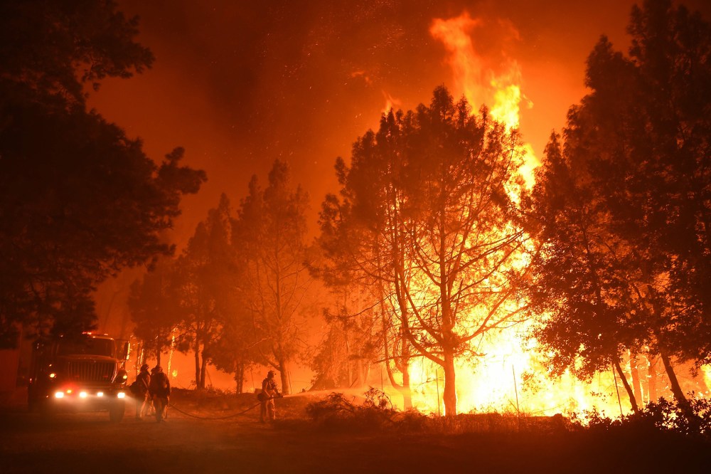 Firefighters douse flames as they approach the Casa Loma fire station in the Santa Cruz Mountains near Loma Prieta, Calif. on Sept. 27, 2016. (Photo by Josh Edelson/AFP/Getty)
