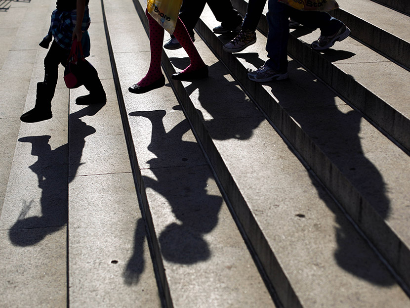 School children walk down the steps of a school.