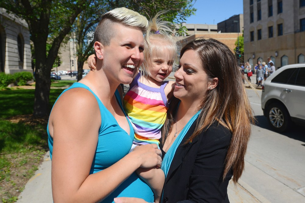 Berri West, left, and new spouse Lisa West, right, hold their daughter Sylas just before they were married Monday, June 9, 2014, after the Brown County Clerk's office began issuing marriage licenses to same sex couples.