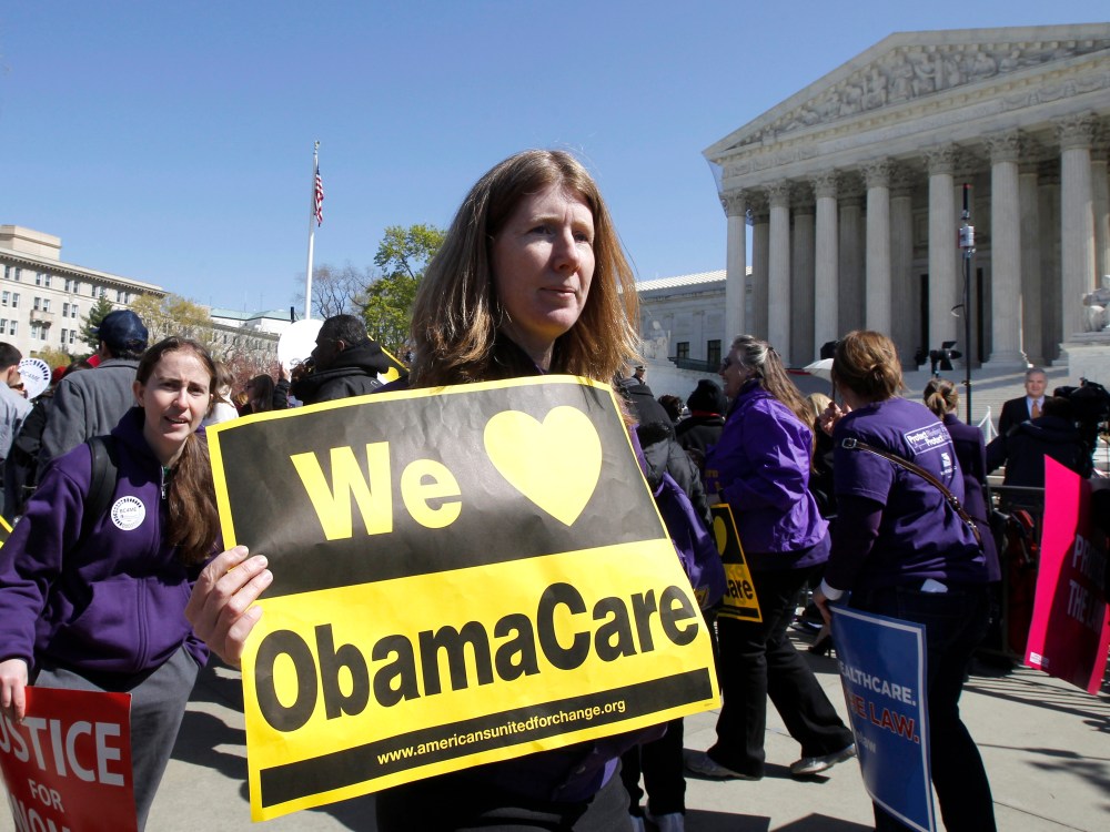 File Photo: Holding a sign saying "We Love ObamaCare" supporters of health care reform rally in front of the Supreme Court in Washington, Tuesday, March 27, 2012, as the court continued hearing arguments on the health care law signed by President...