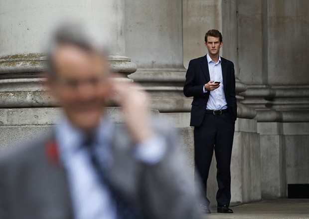 Workers use their mobile phones in London's City financial district, Friday, June 29, 2012. (Photo by Lefteris Pitarakis/AP)