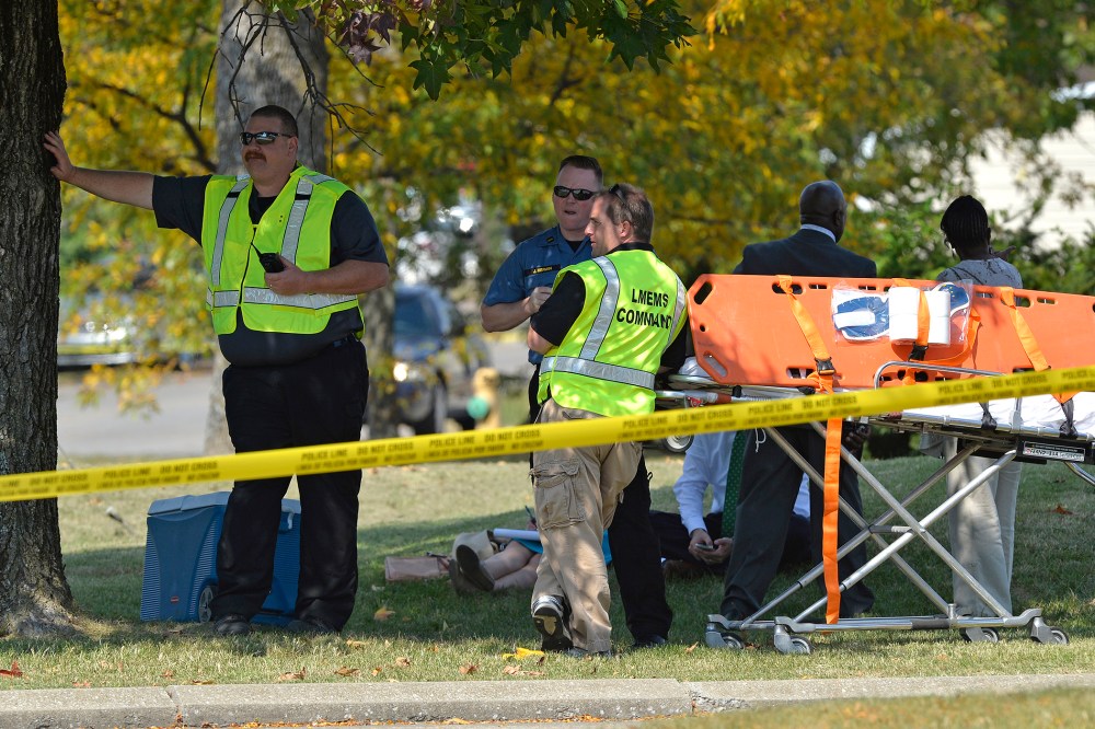 Members of the Louisville Metro Emergency Medical Services wait as units of the Louisville SWAT team search Fern Creek High School Tuesday, Sept. 30, 2014 in Louisville, Ky.