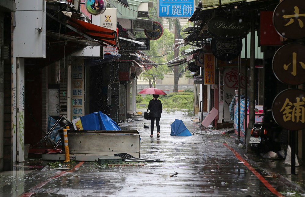 A woman walks down a back alley filled with debris from Typhoon Soudelor in Taipei, Taiwan, Aug. 8, 2015, after Soudelor brought heavy rains and strong winds to the island. (Photo by Wally Santana/AP)