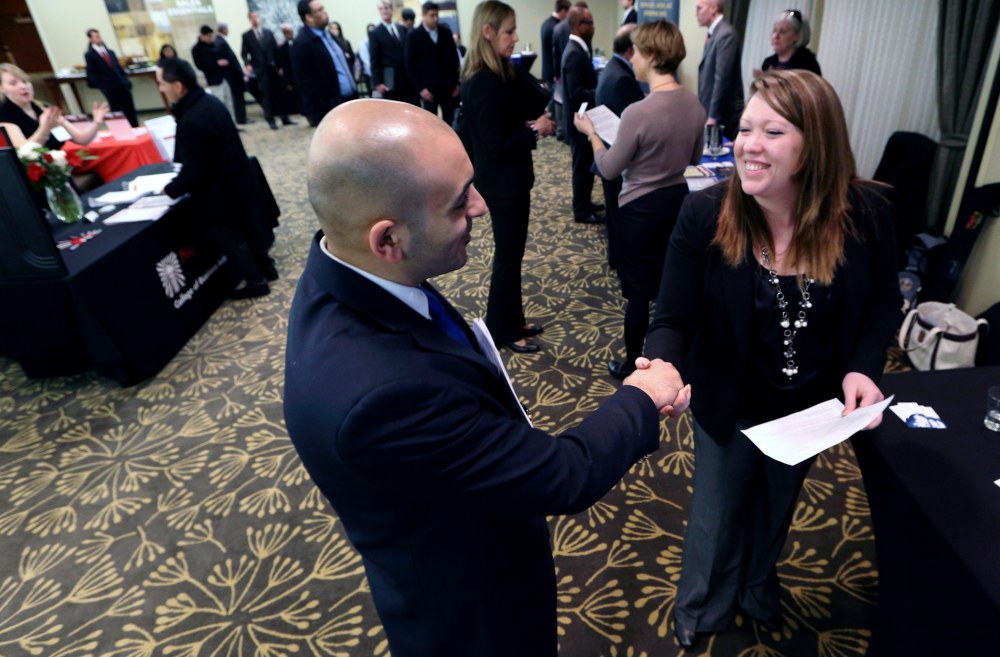 In this Monday, Feb. 25, 2013, photo, Sayed Mouawad, left, of Providence, R.I., shakes hands with Jillian Wallace of Matix, Inc., during a job fair in Boston. The number of people seeking U.S. unemployment aid fell to a seasonally adjusted 340,000 in...
