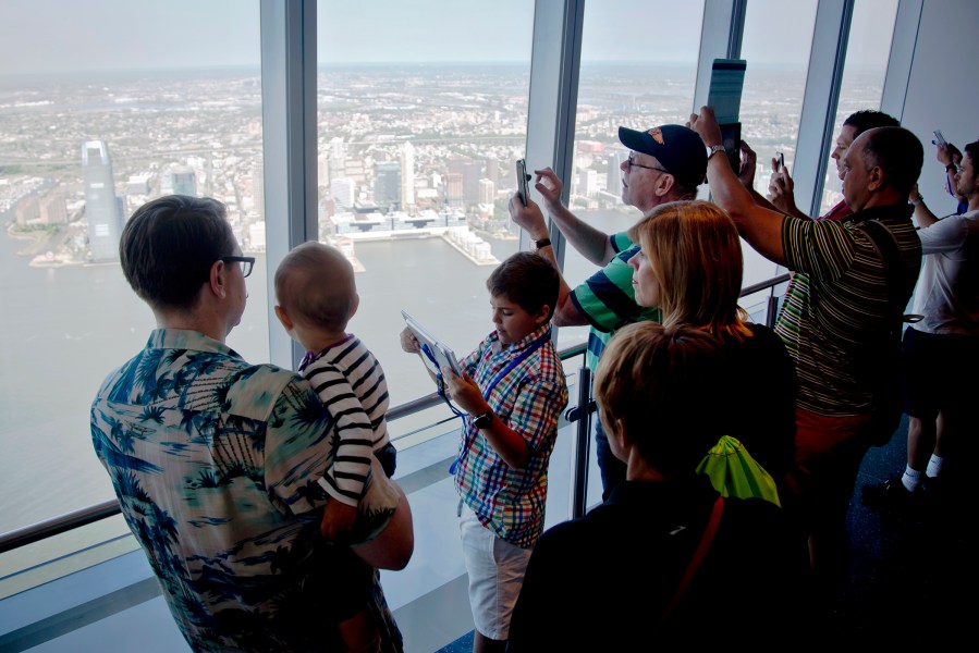 Visitors to One World Observatory take pictures and view parts of New Jersey after a ribbon-cutting ceremony on May 29, 2015, in N.Y. (Photo by Bebeto Matthews/AP)
