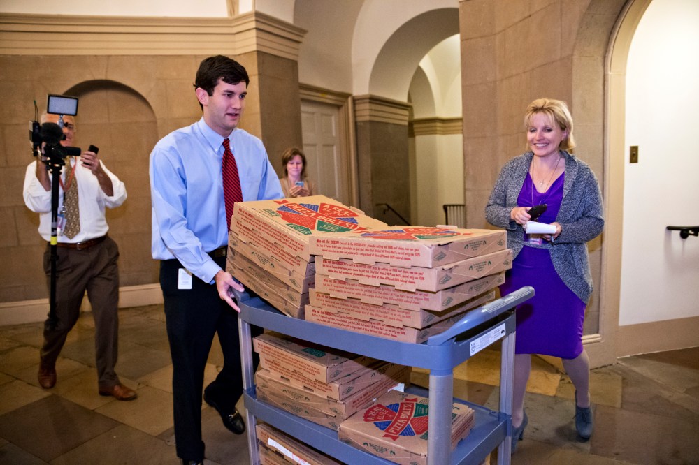 An aide brings a cart stacked with pizza to the office of Speaker of the House John Boehner, as movement toward ending the government shutdown was suddenly halted, at the Capitol in Washington, Tuesday night, Oct. 15, 2013.