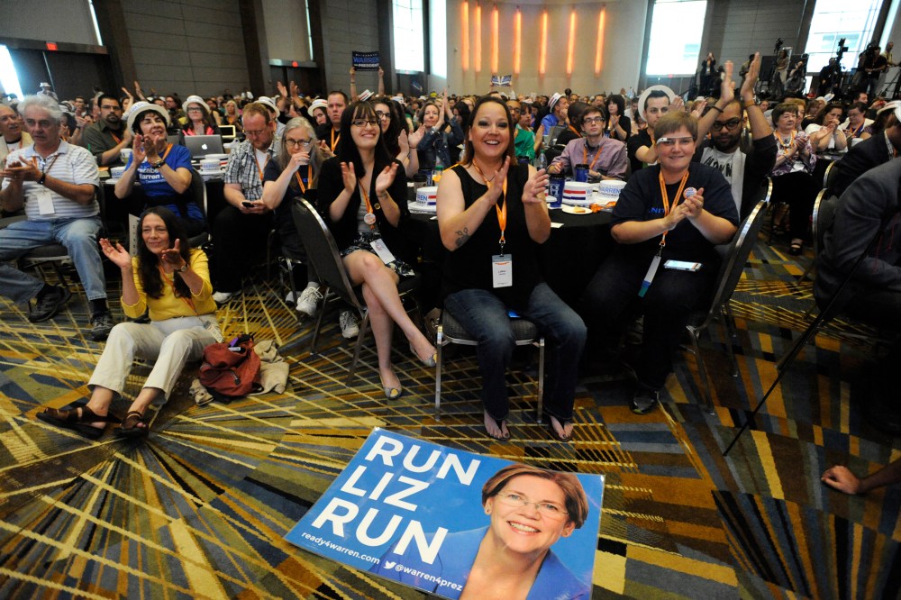 A "Run Liz Run" poster sits on the floor in front of LaNae Havens, center, as she cheers for Sen. Elizabeth Warren, D-Mass., at the Netroots Nation conference in Detroit, Mich., July 18, 2014.
