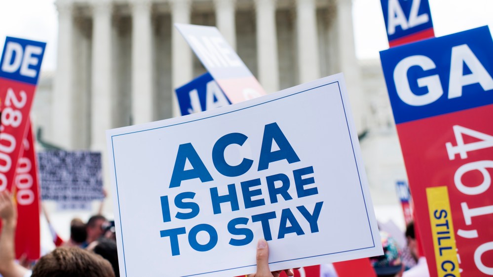 Affordable Care Act supporters wave signs outside the Supreme Court after the court upheld court's Obamacare, June 25, 2015. (Photo By Bill Clark/CQ Roll Call/AP)