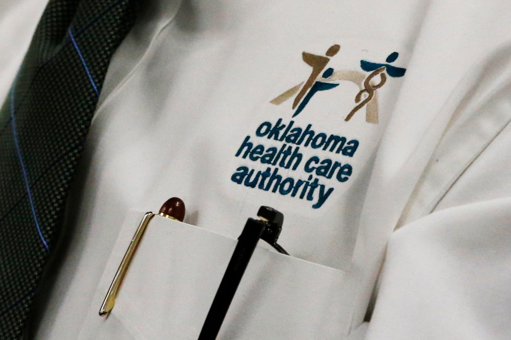 An audience member wears an Oklahoma Health Care Authority shirt during an OHCA board meeting in Oklahoma City, July 1, 2014.