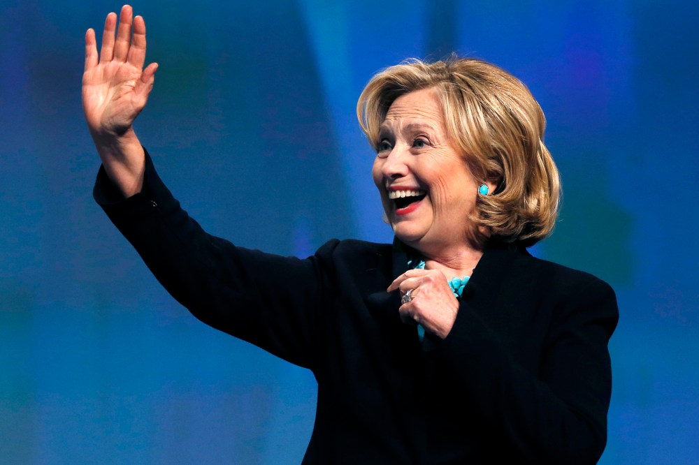 Former Secretary of State Hillary Rodham Clinton waves as she is introduced at an event in Boston, Mass., Dec. 4, 2014. (Photo by Elise Amendola/AP)
