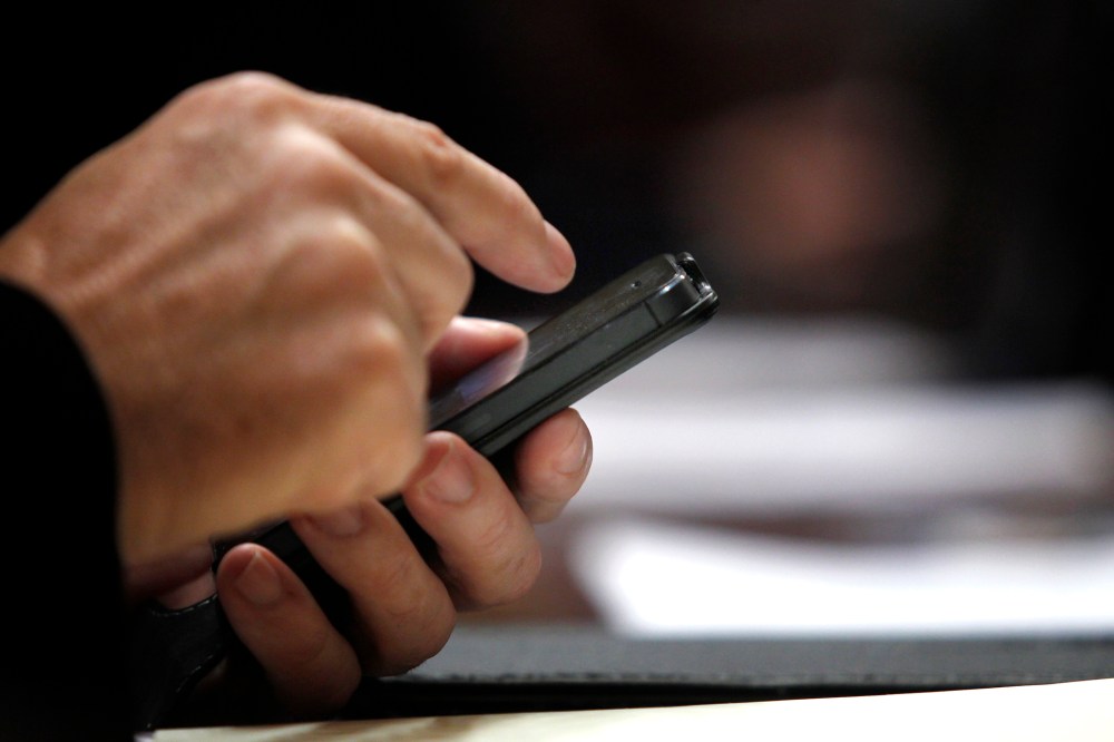 A Spanish lawmaker uses his cell phone in Madrid on Oct. 30, 2013.