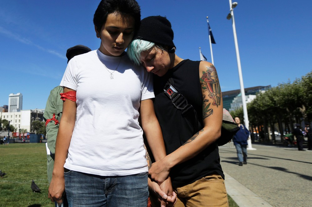 Gabriela Serrano, 21, left, and A.J. James, 27, listen to a prayer during a vigil for Michael Brown of Ferguson, Mo., in San Francisco, Thursday, Aug. 14, 2014.