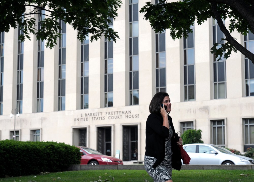 A woman talks on the phone in front of the U.S. Courthouse in Washington, Thursday, June 6, 2013, where the secret Foreign Intelligence Surveillance Court resides. (AP Photo/Cliff Owen)