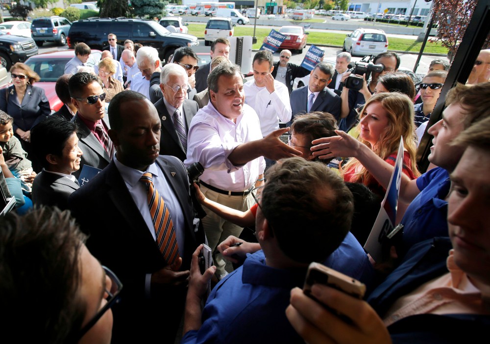 New Jersey Gov. Chris Christie, center, reaches to shake a hand as he greets supporters during a campaign stop in Edison, N.J. on Tuesday, Oct. 8, 2013.