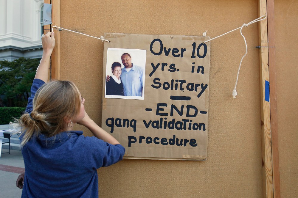 Georgia Valentine hangs a poster calling for reform in the use of solitary confinement in California prisons, Oct. 9, 2013.