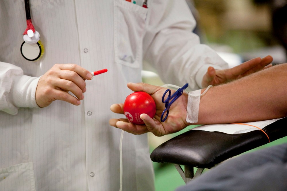 In this Nov. 1, 2014 photo, Kimilee Day, a team leader with the American Red Cross, prepares a patient to give blood during a blood drive at First United Methodist Church in Decatur, Ill. (Photo by Danny Damiani/Herald & Review/AP)