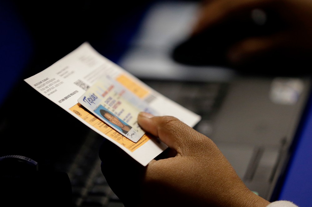 An election official checks a voter's photo identification at an early voting polling site, in Austin, Texas. (Eric Gay/AP)