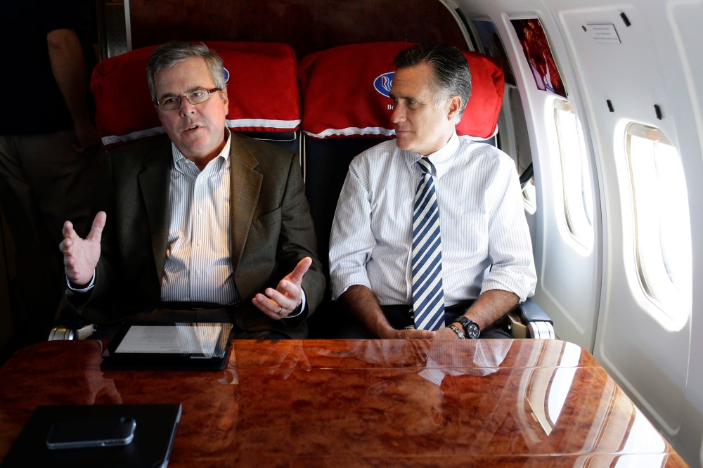 Republican presidential candidate, former Massachusetts Gov. Mitt Romney talks with former Florida Gov. Jeb Bush as they fly on his campaign plane to Miami Fla., Oct. 31, 2012. (Photo by Charles Dharapak/AP)
