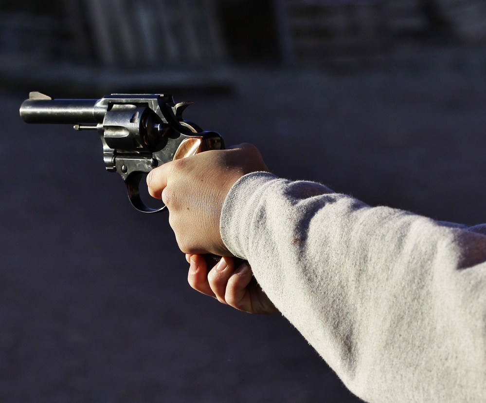 A man shoots a revolver, at Dragonman's firing range and gun dealer, outside Colorado Springs, Colo., Sunday Dec. 23, 2012. (Photo by Brennan Linsley/AP)