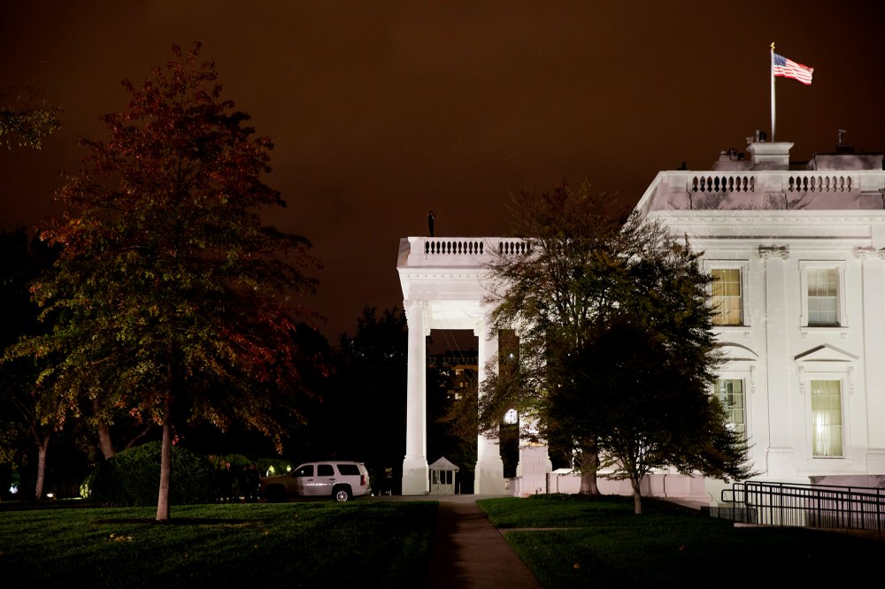A group of Secret Service police gather on the North Lawn as a member of the Secret Service Counter Assault team surveys from the White House rooftop, Oct. 22, 2014, in Washington, D.C. (Photo by Jacquelyn Martin/AP)