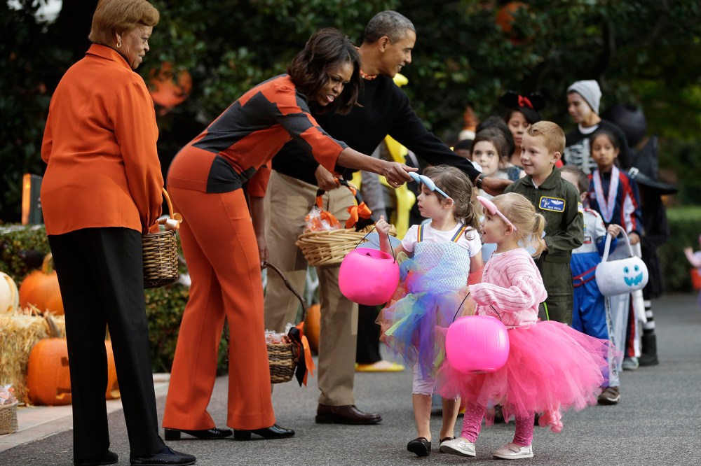 President Barack Obama, first lady Michelle Obama and her mother Marian Robinson, far left, hand out Halloween treats to 'trick-or-treaters' on the South Lawn of the White House in Washington, D.C., on Oct. 31, 2013. (Photo by Pablo Martinez Monsivais/AP)