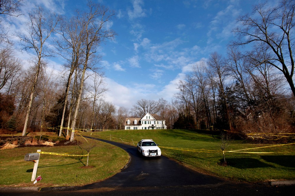 A police cruiser sits in the driveway as crime scene tape surrounds the home of Nancy Lanza, Dec. 18, 2012, in Newtown, Conn. (Photo by Jason DeCrow/AP)